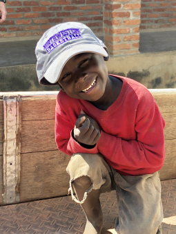 A child in Malawi wearing a Northwestern University basketball cap.